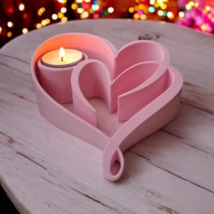 Ein rosafarbener Herz Teelichthalter aus dem 3D-Drucker, der mit einem leuchtenden LED-Teelicht auf einem rustikalen Holztisch eine romantische Stimmung verbreitet.