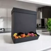 Ein mattschwarzer Allzweck Spender aus dem 3D-Drucker, der als praktische Candy-Bar mit bunten Bonbons gefüllt auf einer weissen Küchentheke steht.