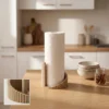 Ein beigefarbener gerippter Küchenrollenhalter "Forma" aus dem 3D-Drucker, der eine weisse Papierrolle auf einer eleganten Küchenarbeitsplatte hält.