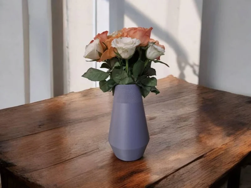 Nahaufnahme der ägyptisch inspirierten Vase, die auf einem rustikalen Holztisch steht und elegant mit frischen Rosen dekoriert ist.