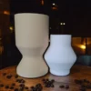 Ein minimalistisches Vasen Set aus dem 3D-Drucker in den Farben Beige und Weiss, das auf einem rustikalen Holztisch perfekt ineinandergreift.