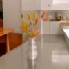 Eine weisse Tulpen Design Vase aus dem 3D-Drucker mit rauer Fuzzy-Skin-Oberfläche, die mit bunten Trockenblumen auf einem Holztisch dekoriert ist.